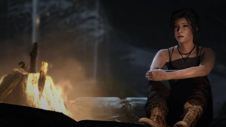 Lara se aquece em uma fogueira.
