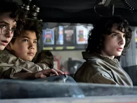 McKenna Grace, Logam Kim e Finn Wolfhard olhando de maneira séria pela janela do carro em Ghostbusters: Mais Além