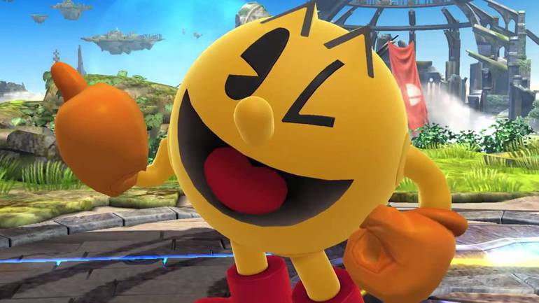 Imagem mostra Pac-Man em Super Smash Bros. Ultimate. O mascote amarelo está piscado seu olho direito e fazendo um joinha com a mão direita.