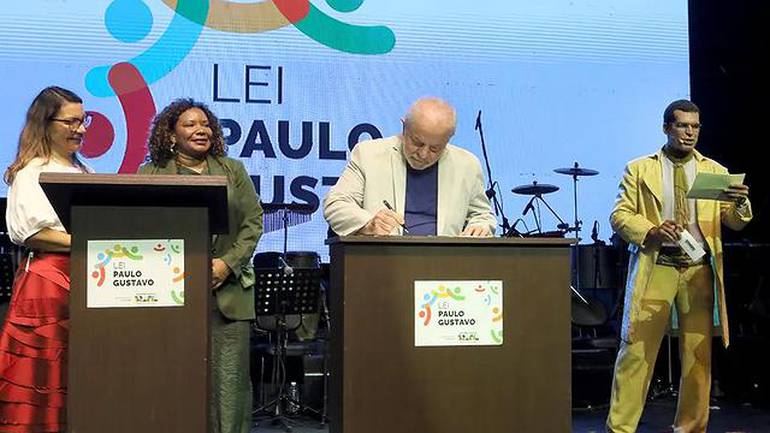 Foto mostra o Presidente Lula apresentado o decreto que vibializa a Lei Paulo Gustavo