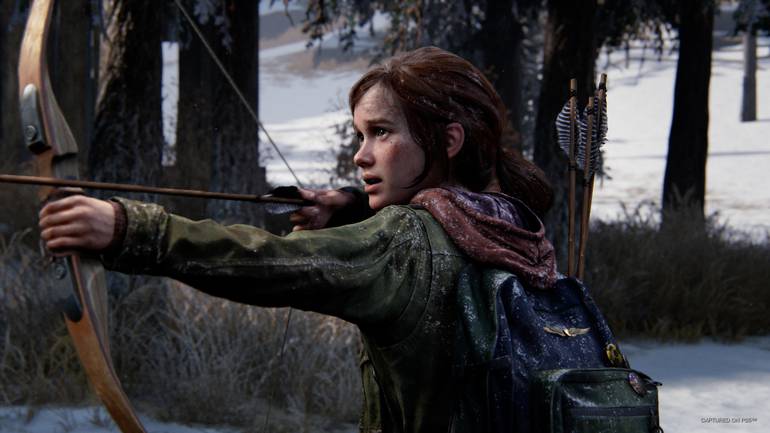 Cena de The Last of Us Part I mostra Ellie em um campo de neve caçando com a ajuda de um arco e flecha